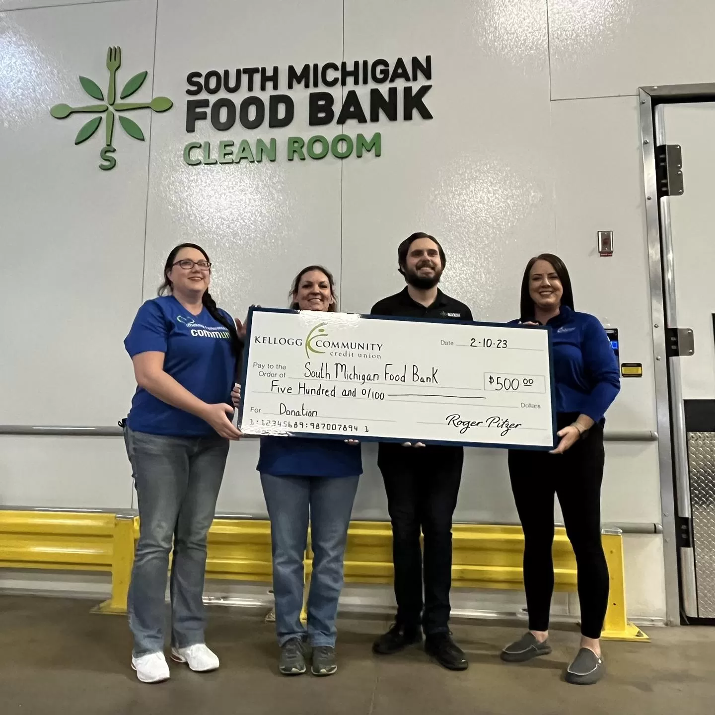 KCCU team presents check to South Michigan Food Bank